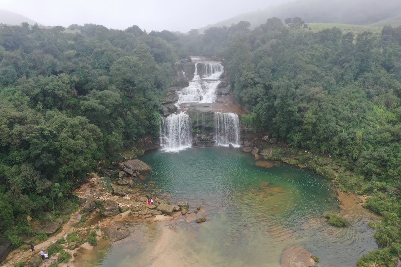 services-img-02 Stunning aerial view of a waterfall surrounded by dense jungle in Meghalaya, India.